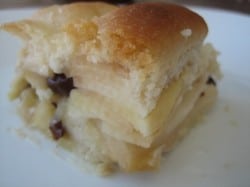 Slice of apple pie cake with alternating apple and crust layers on a white plate.