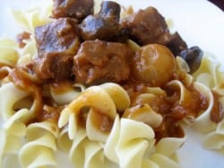 Pasta noodles topped with beef burgundy sauce, pearl onions, and beef.
