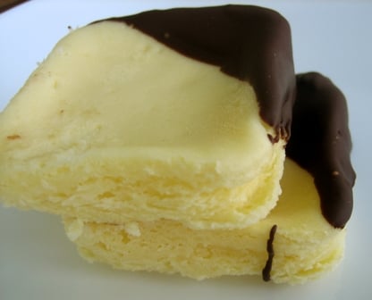 Square cheesecake truffles with a corner dipped in chocolate.