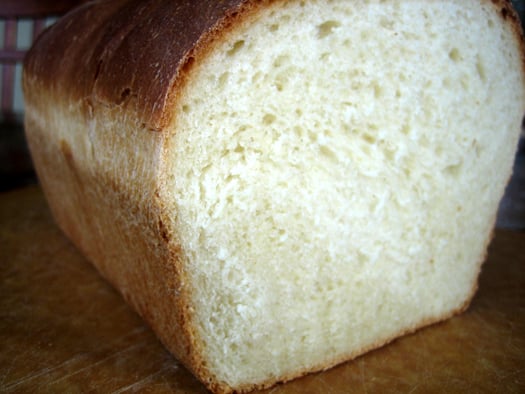 Sandwich bread loaf with a slice cut off showing the bread texture.