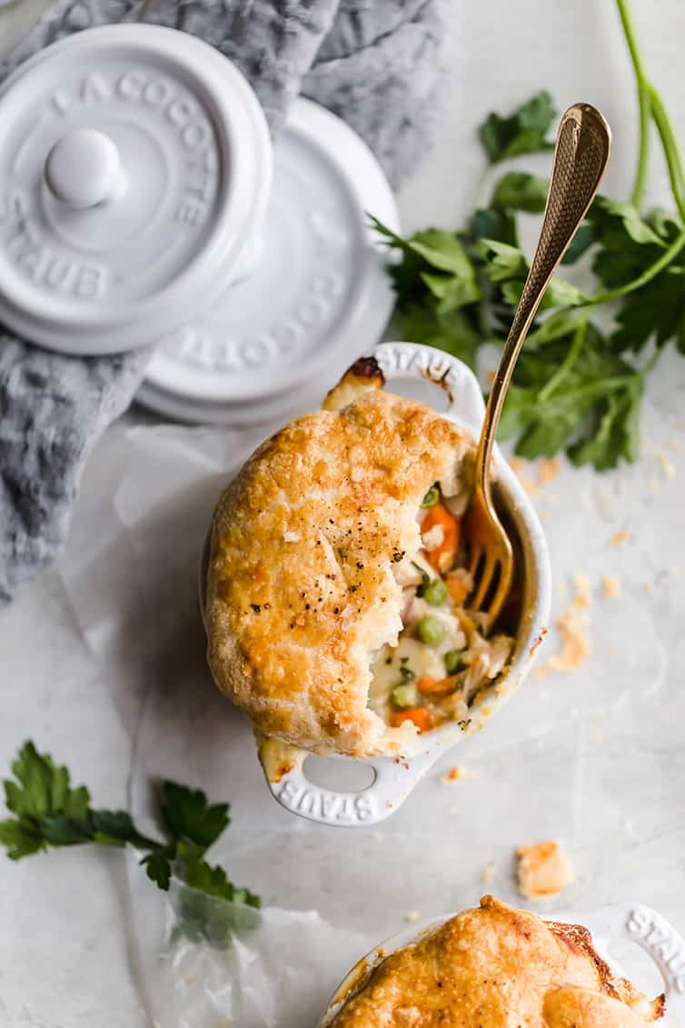 An overhead shot of a half-eaten ramekin of chicken pot pie.