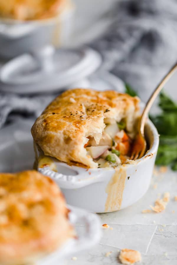 Chicken pot pie in a ramekin with half eaten.