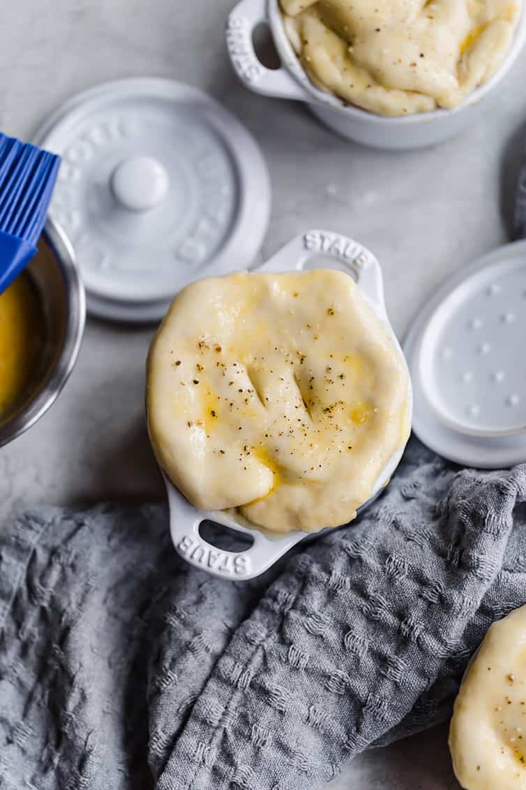 Assembled chicken pot pie in a ramekin with dough on top.