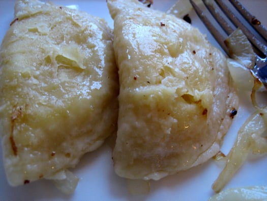 2 pierogies on a white plate.
