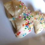 Italian fig cookies with sprinkles on a white plate.