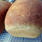 2 loaves of anadama bread on a cooling rack.