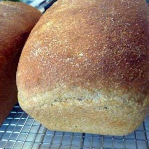 2 loaves of anadama bread on a cooling rack.