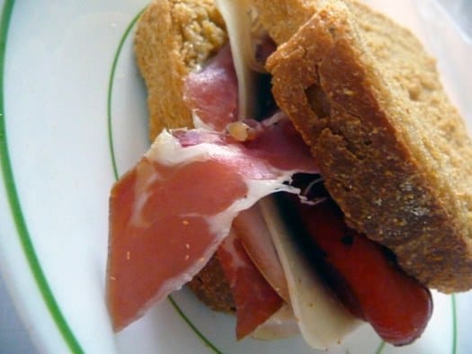 Sandwich made with anadama bread on a white plate.