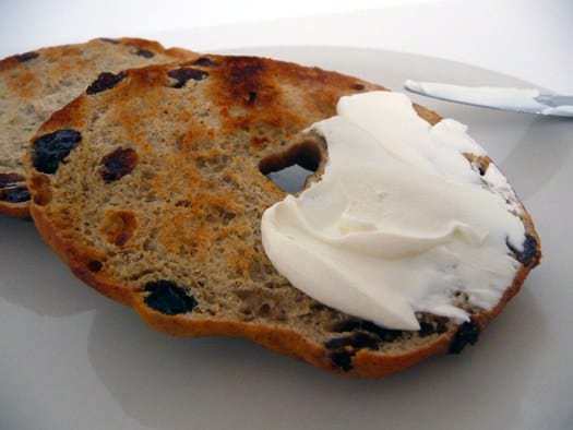 Cinnamon raisin bagel cut in half with cream cheese.