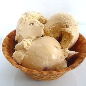 Scoops of butter pecan ice cream in a waffle bowl.