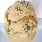 2 scoops of pistachio nut ice cream in an ice cream cone.