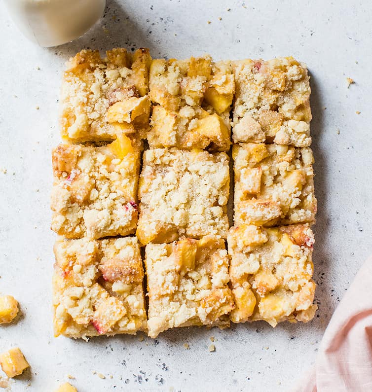 Peach crumb bars cut into nine squares.