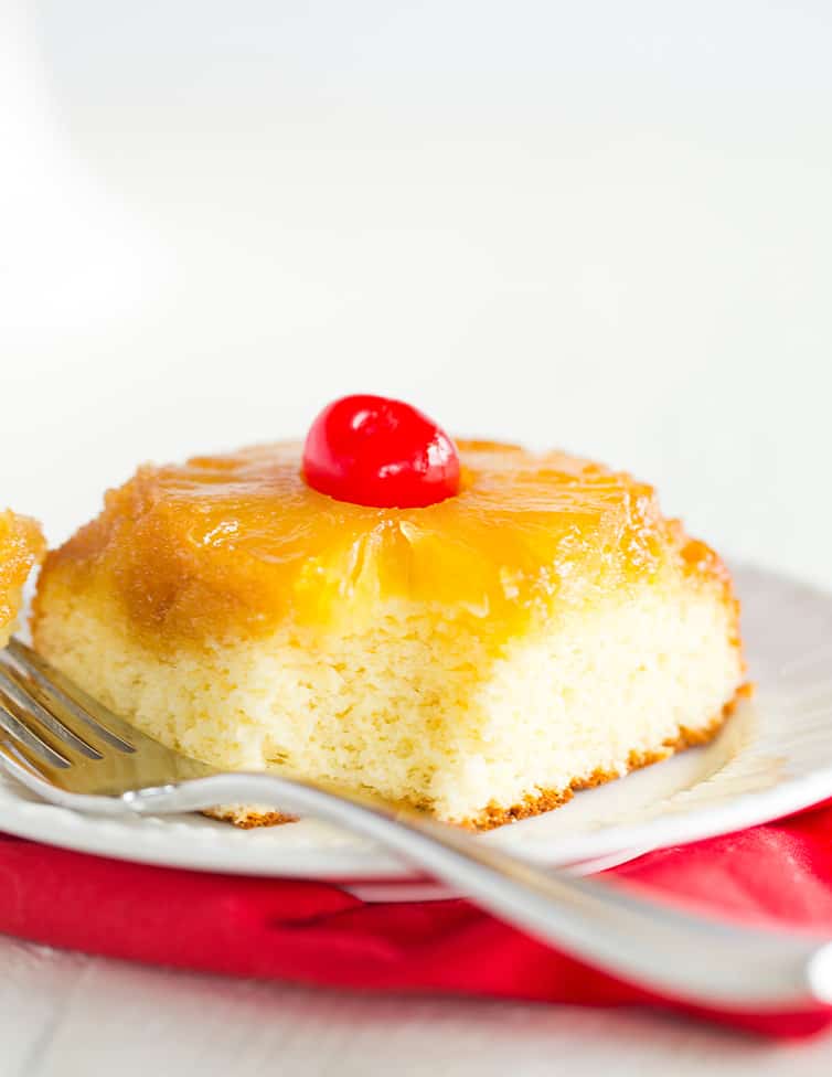A piece of pineapple upside down cake with a bite taken out.