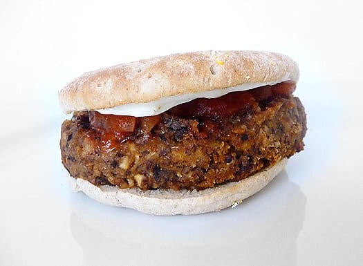 Black bean mushroom burger on a bun with cheese and ketchup.