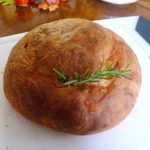 Loaf of potato rosemary bread with a rosemary sprig on top.