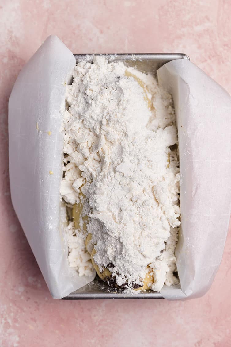 A loaf of babka with streusel sprinkled in top, before being baked.