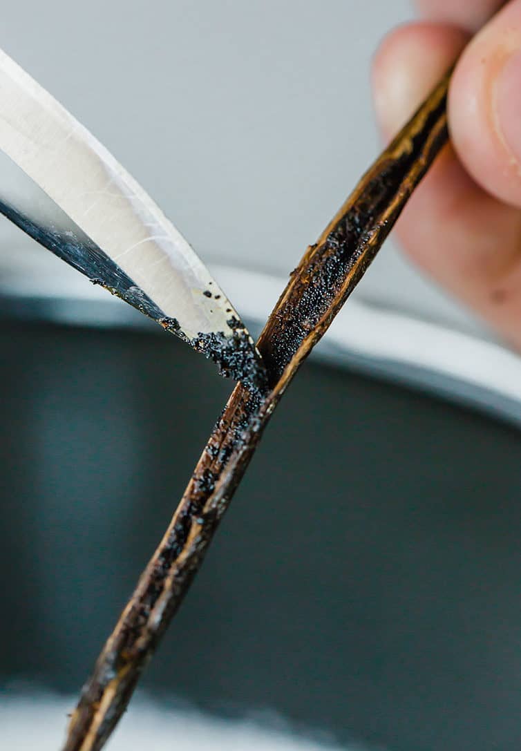 Scraping vanilla bean seeds with a paring knife.