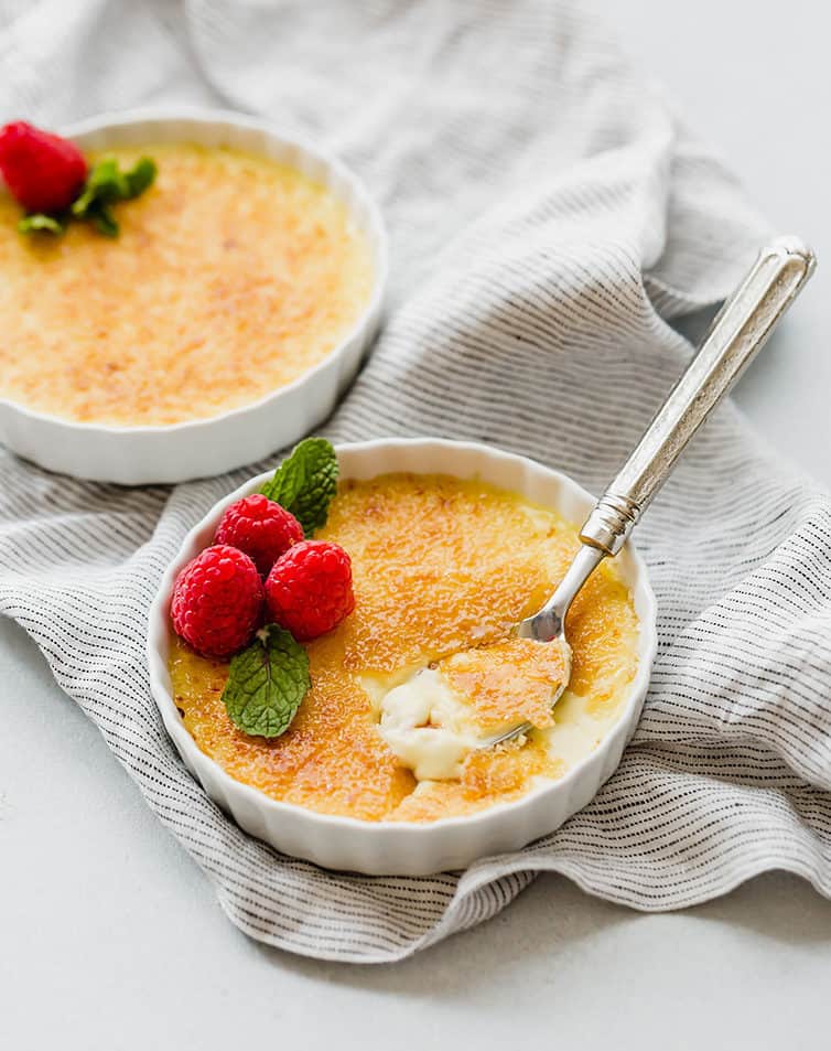Two ramekin bowls of creme brulee.