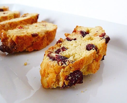 Cranberry white chocolate almond biscotti on a white plate.