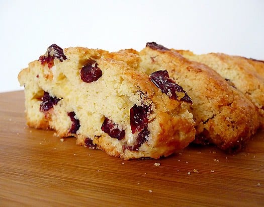 Cranberry white chocolate almond biscotti on a wood board.