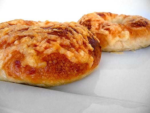 2 asiago bagels on a white plate.