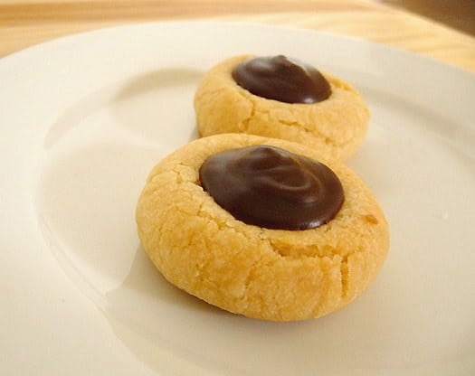2 chocolate thumbprint cookies on a white plate.