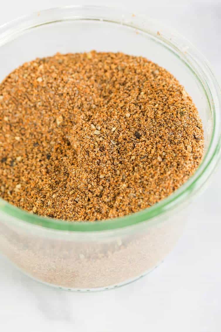 A glass jar full of homemade taco seasoning mix.