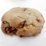Pecan sandie cookie on a white plate.