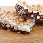 2 pieces of toffee pretzel bark on a wood serving platter.