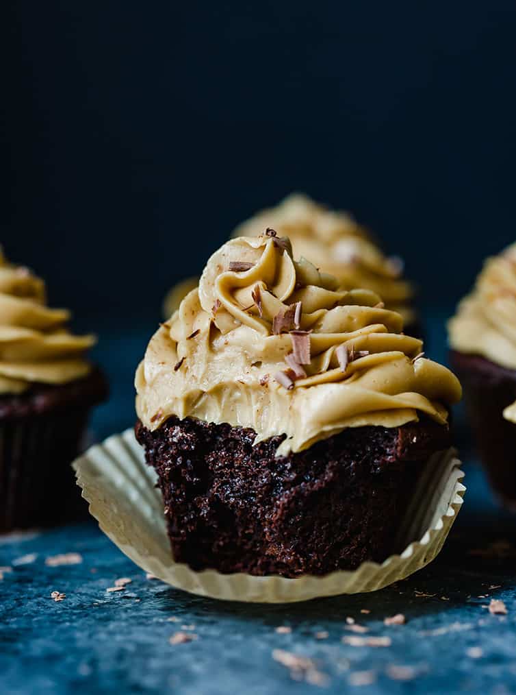 Chocolate cupcake with peanut butter frosting with a bite taken out.