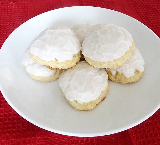 Frosted anise cookies on a white plate.