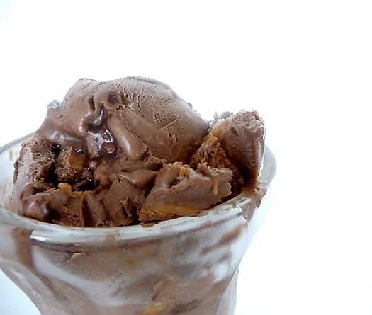 Scoops of chocolate fudge swirl peanut butter ice cream in a glass.