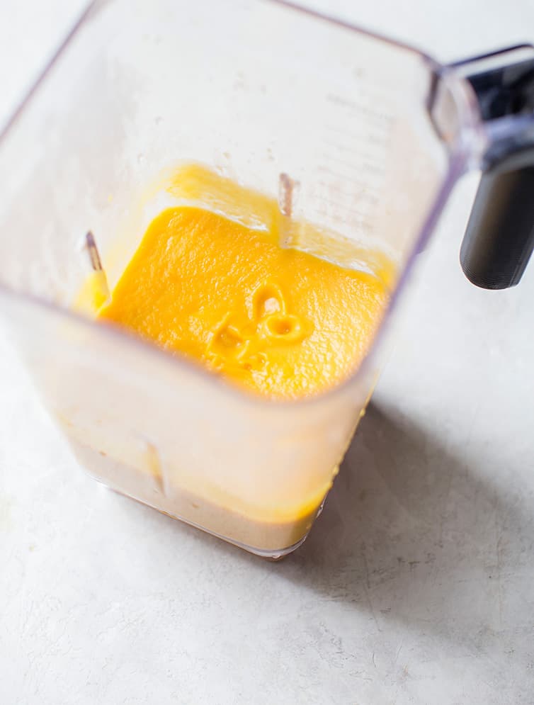 Pureed butternut squash soup in a blender.