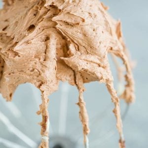 Stand mixer whisk attachment with a ton of chocolate frosting.