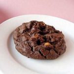 A salted double chocolate peanut butter cookie on a white plate.