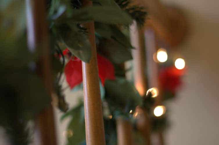 Lit garland on the stairway railing.