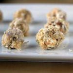 Date, coconut, and walnut truffles on a ceramic serving tray.