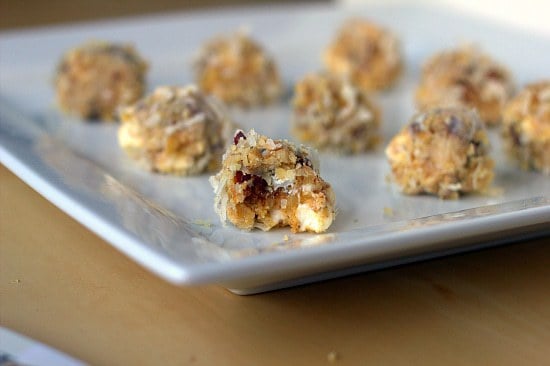 Date, coconut, and walnut truffles on a ceramic serving tray.
