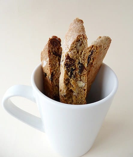 Fig and walnut biscotti in a white mug.