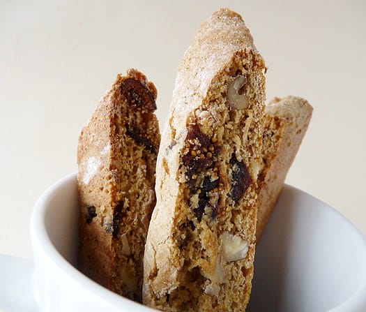 Fig and walnut biscotti in a white mug.