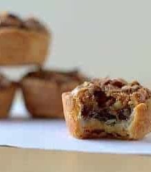 Pecan tassies with a bite taken from one.