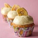 Banana cupcakes topped with vanilla pastry cream and a banana chip.