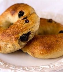 2 blueberry bagels on a white plate.
