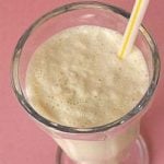 Malted vanilla milkshake in a glass with a straw.