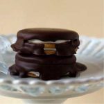 Stack of 2 moon pies on a white dessert stand.