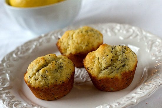 3 lemon poppy seed muffins on a white plate.