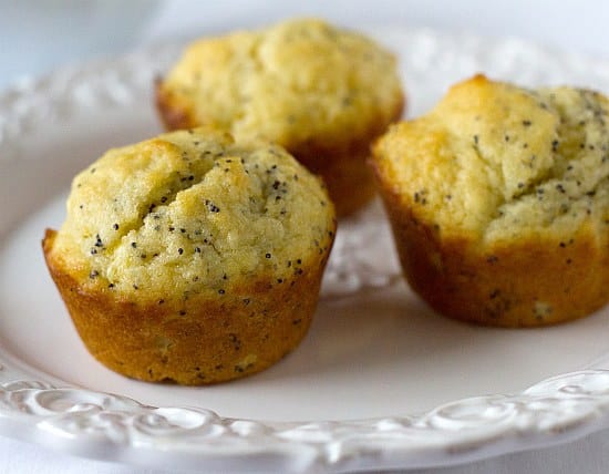 3 lemon poppy seed muffins on a white plate.