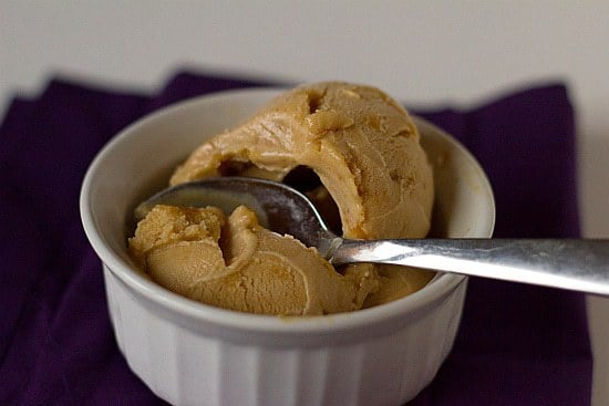 Scoops of salted caramel ice cream in a white bowl with a spoon.