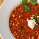 Overhead image of gazpacho in a white bowl.