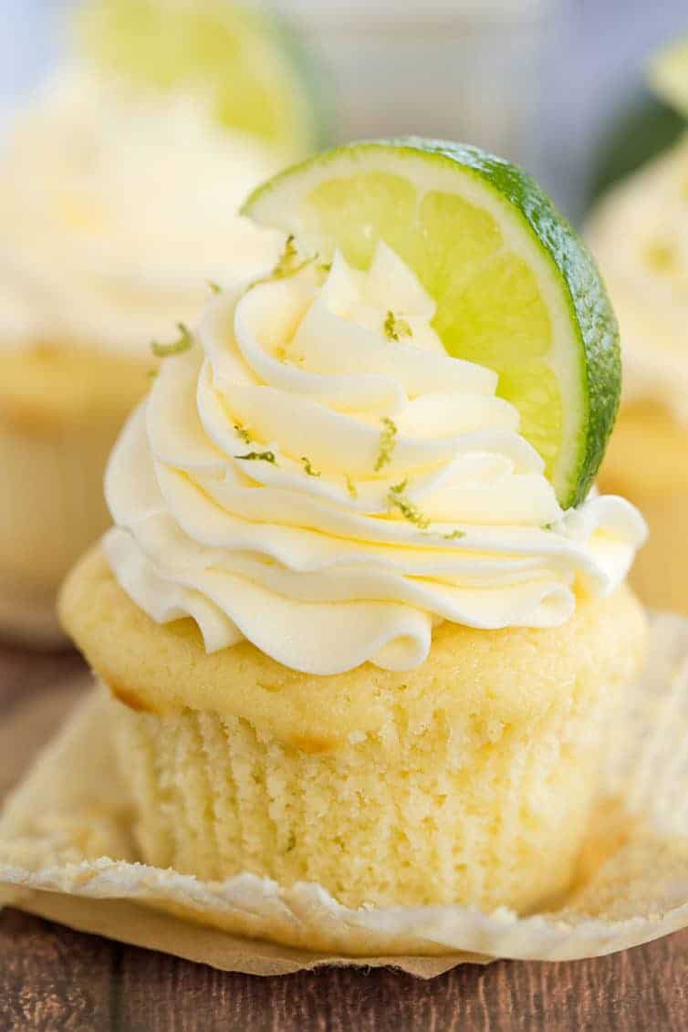 Margarita Cupcake - Vanilla cupcake with the paper liner pulled away. It's topped with lime zest and a lime wedge.